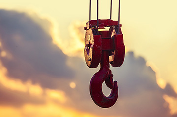 lifting rig on a crane with sun setting behind it